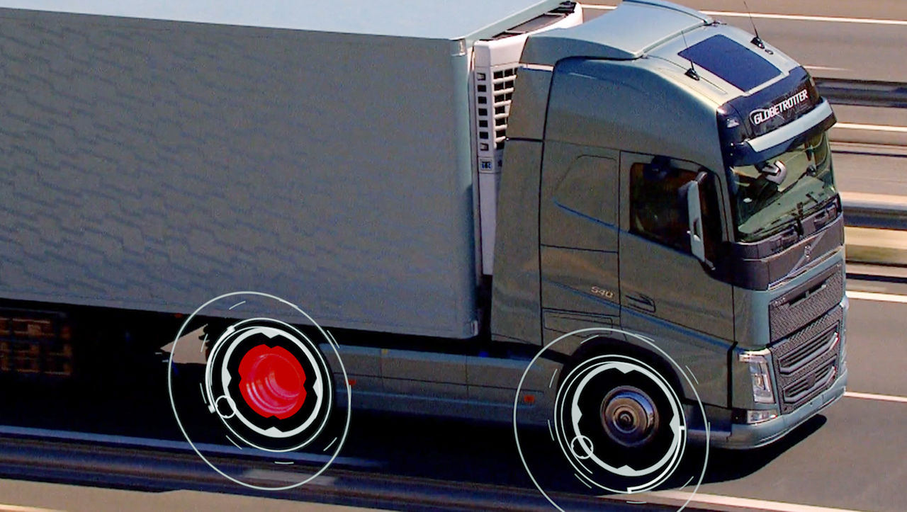 Een wagen van Volvo Action Service geparkeerd naast een vrachtwagen onder een viaduct